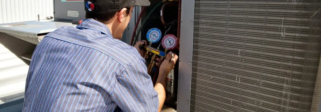 HVAC technician servicing a condenser unit in Northchase